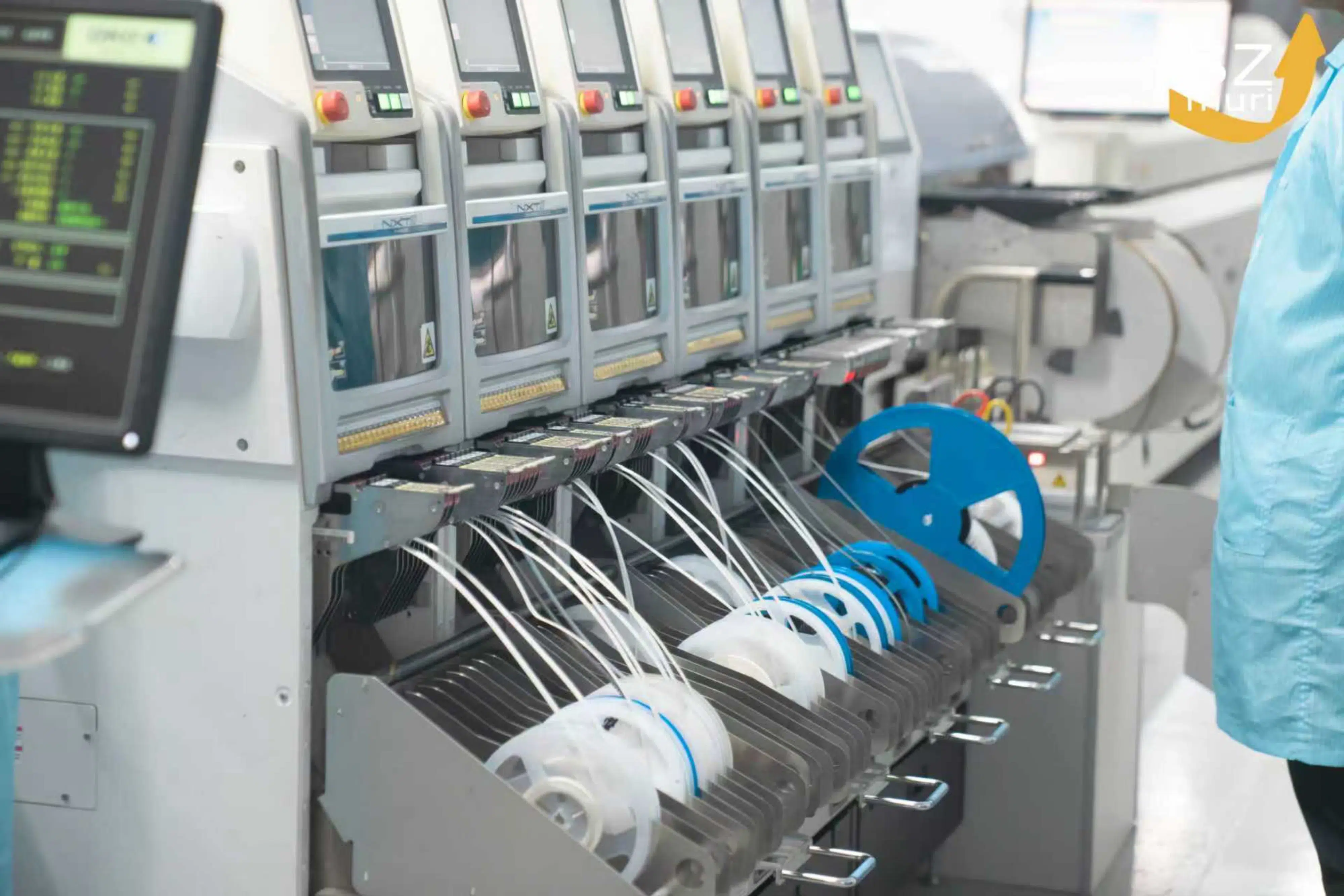 Eine moderne Maschine mit blauen und weißen Kabelspulen produziert elektronische Bauteile